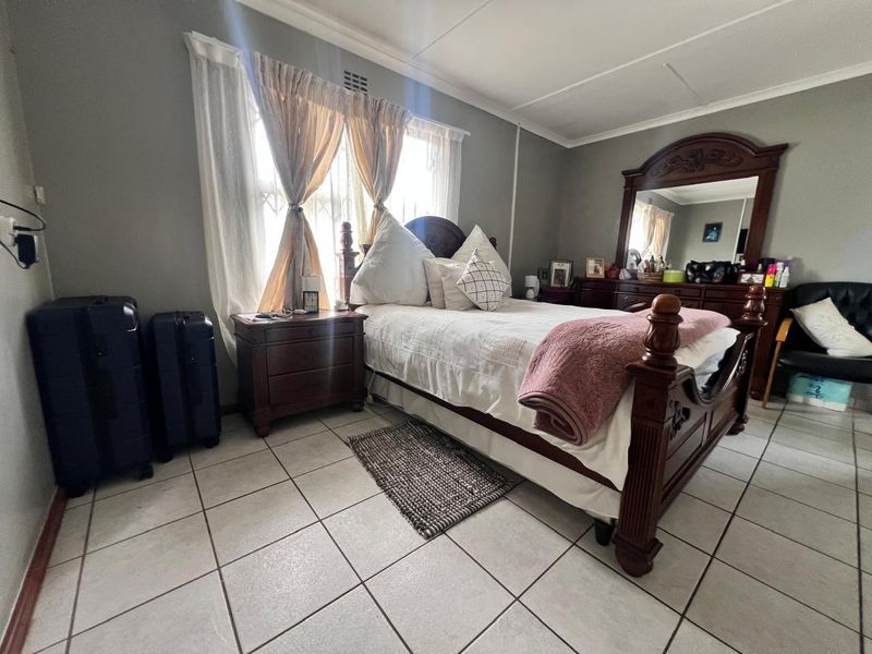 A bedroom featuring tiled flooring and neutral wall finishes, providing a functional space with natural light from the window.