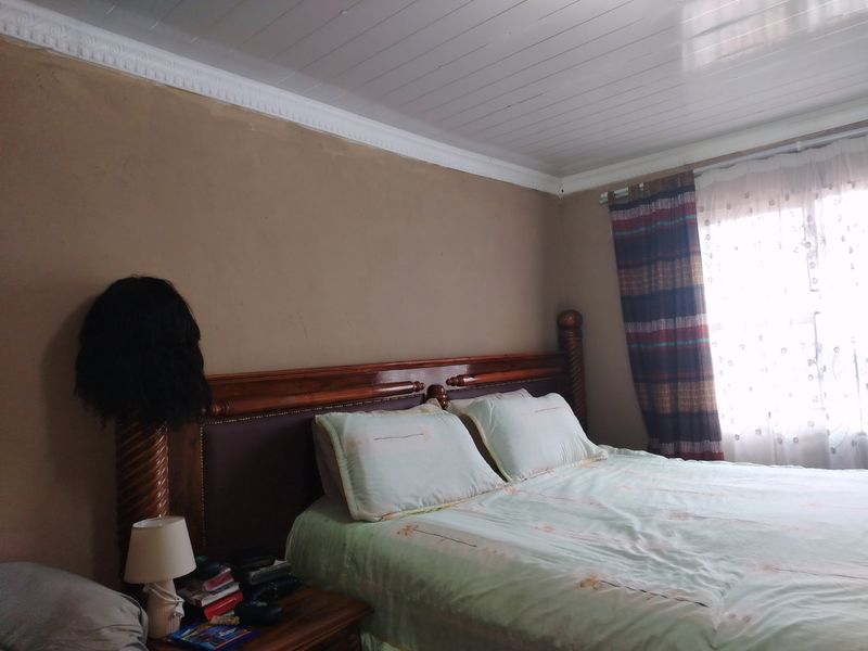 A bedroom featuring a tongue and groove ceiling with crown molding and plain wall finishes.