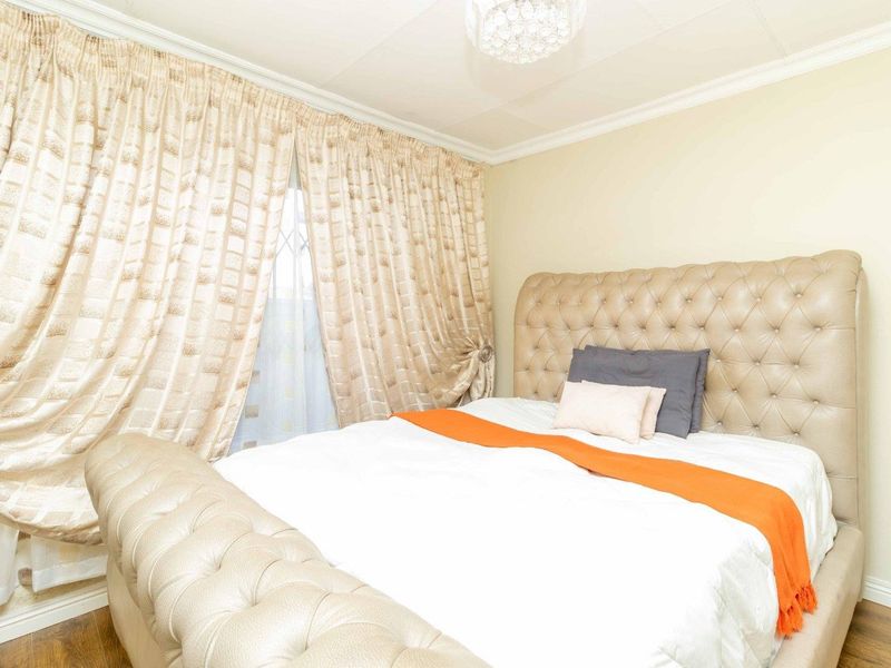 A bedroom featuring laminate flooring, ceiling cornice, and a central light fixture.