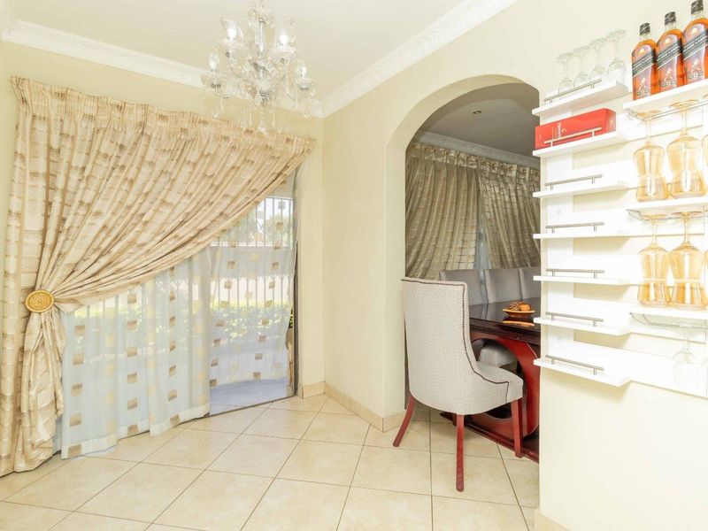 Dining area featuring tiled flooring, an elegant archway leading to an adjacent space, and a sliding glass door providing access to the exterior.
