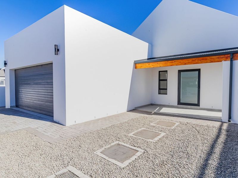 Modern front facade featuring a clean white finish, a single garage, and a covered entrance with timber detailing.