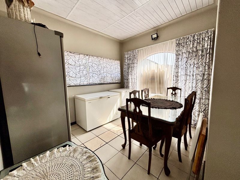 Dining area featuring tiled flooring, an arched window with curtains, and a tongue and groove ceiling.