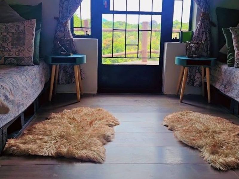 A cozy bedroom featuring laminate flooring and a secure glass door leading to an outdoor view.