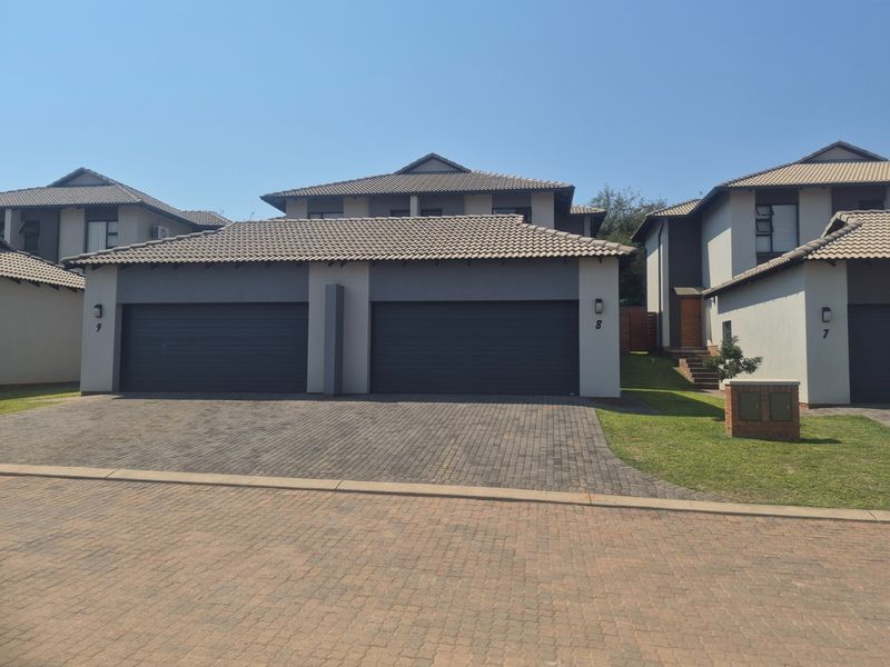 Front elevation of a modern residential property featuring a double garage, paved driveway, and well-maintained exterior finishes.