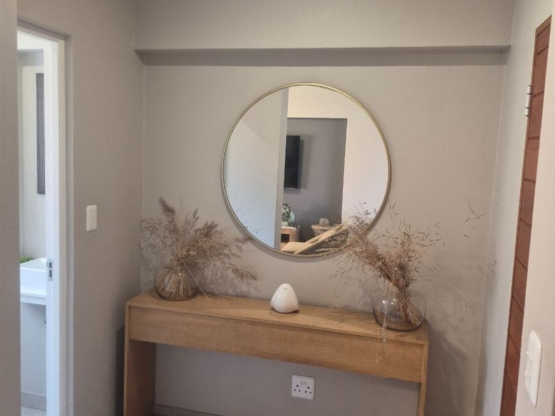 A clean and well-maintained hallway featuring neutral wall tones, tiled flooring, and a functional layout connecting to adjacent rooms.