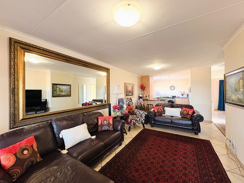 An open-plan living area featuring tiled flooring and a connected kitchen space, providing a functional layout for daily living.