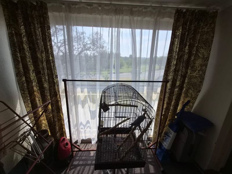 A living area featuring a large sliding glass door with curtain tracks, providing natural light and access to an outdoor space.