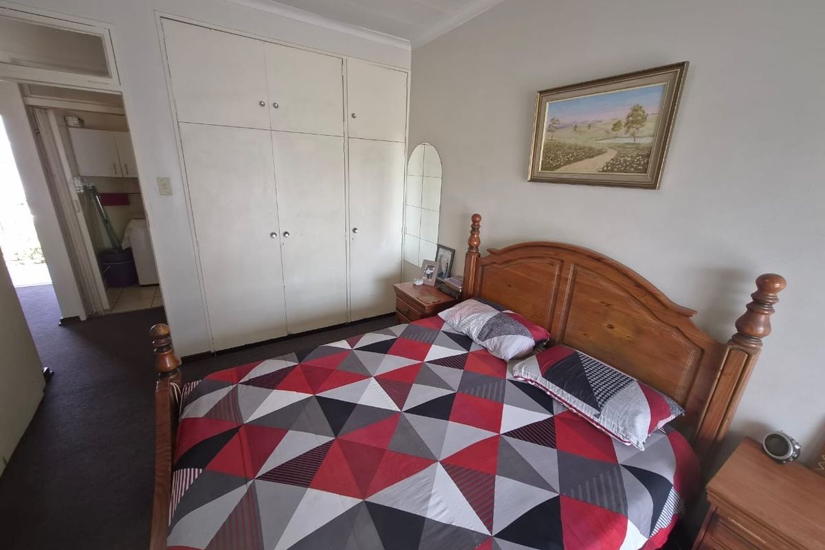 A bedroom featuring built-in cupboards and coved ceiling details, providing functional storage space within the apartment.