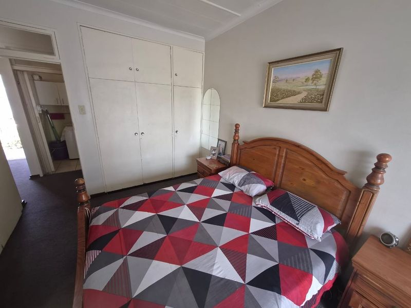 A bedroom featuring built-in cupboards and coved ceiling details, providing functional storage space within the apartment.