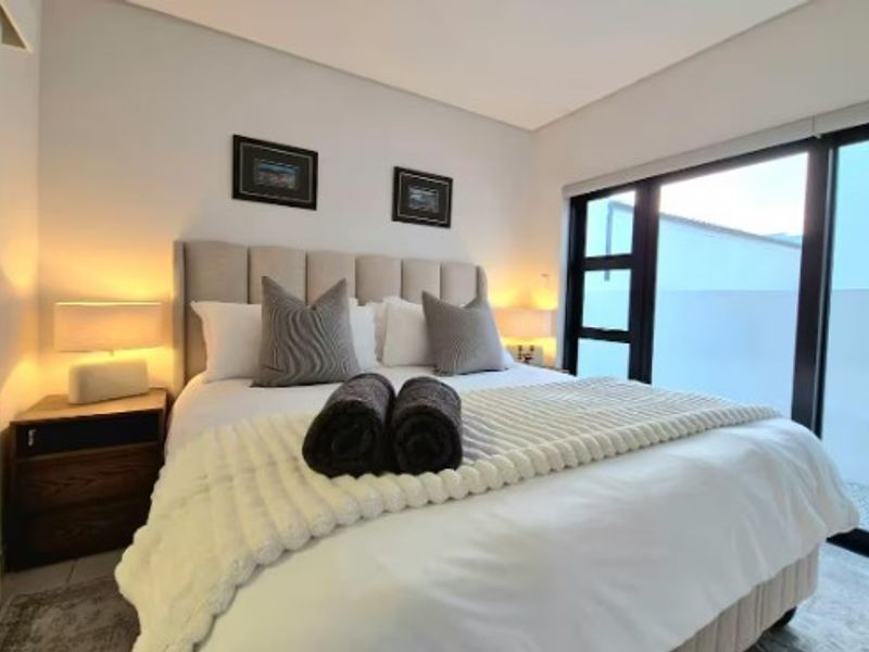 A well-maintained bedroom featuring large sliding glass doors that provide natural light and access to the exterior.
