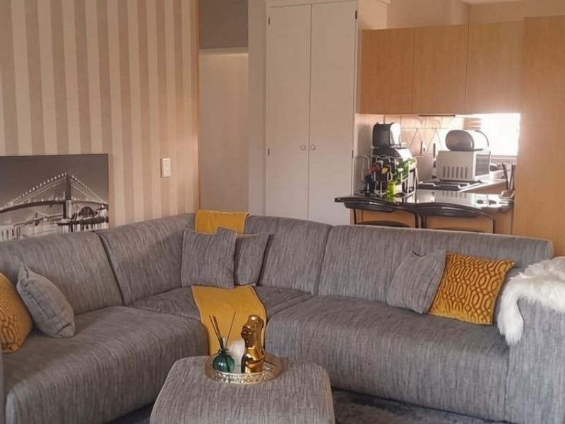 Open plan living area featuring a kitchen with breakfast bar, tiled flooring, and built-in storage, creating a functional and connected living space.