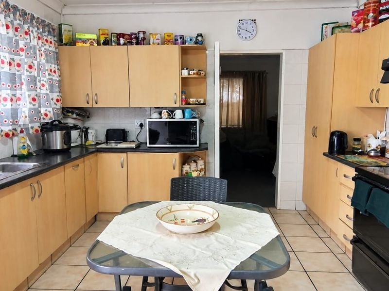 Functional kitchen featuring laminate cabinetry, tiled flooring, and built-in appliances, offering a practical layout with ample storage space.