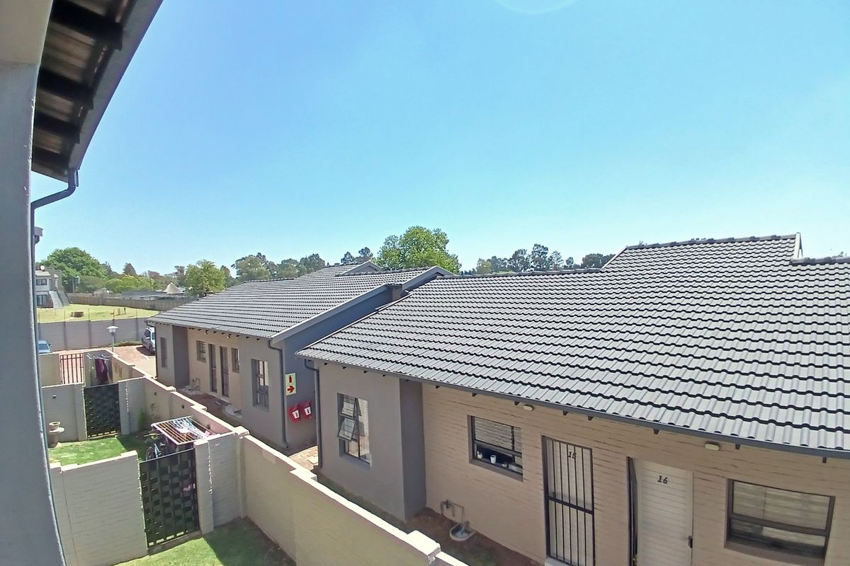 An elevated view of the townhouse complex, showcasing the tiled roofs, boundary walls, and exterior layout of the units.