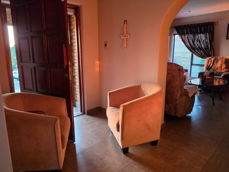 Entrance foyer featuring tiled flooring and an arched transition leading into the main living area, illuminated by natural light from the front door.