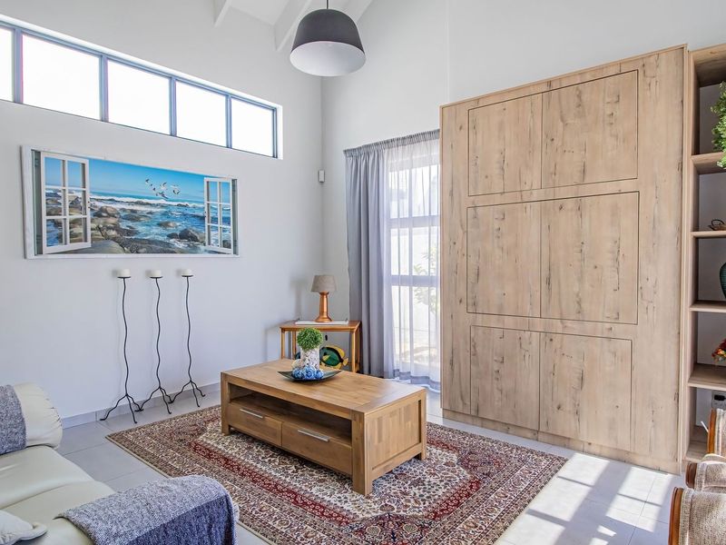 Bright living room featuring vaulted ceilings, clerestory windows for natural light, and extensive built-in wooden cabinetry for storage.