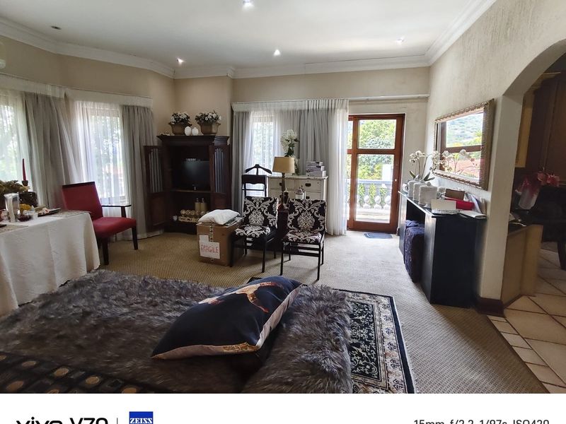 Spacious living area featuring recessed lighting, cove cornicing, and direct access to an outdoor balcony through a glass door.