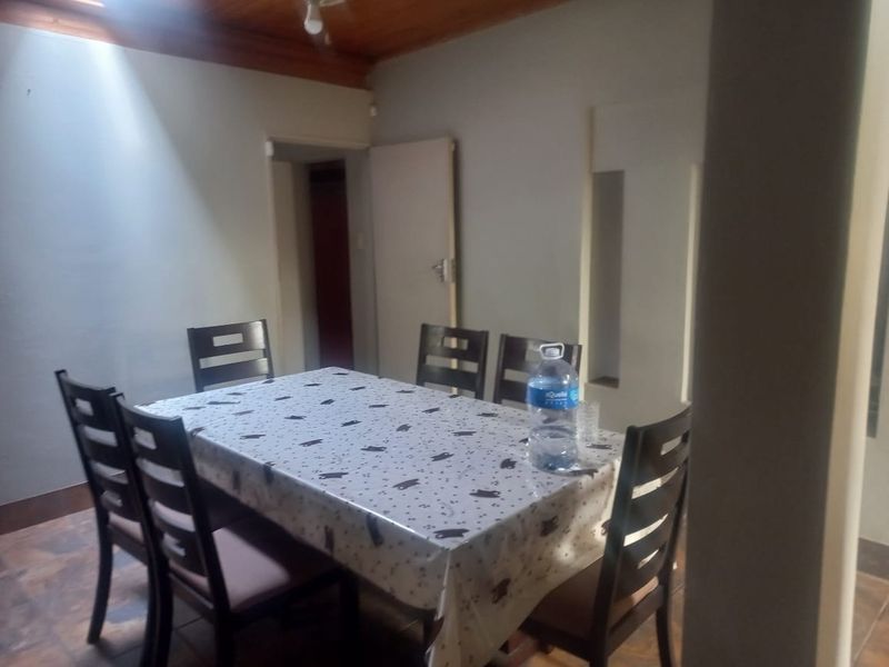 A dining room featuring tiled flooring and a timber ceiling, providing a functional space for family meals.