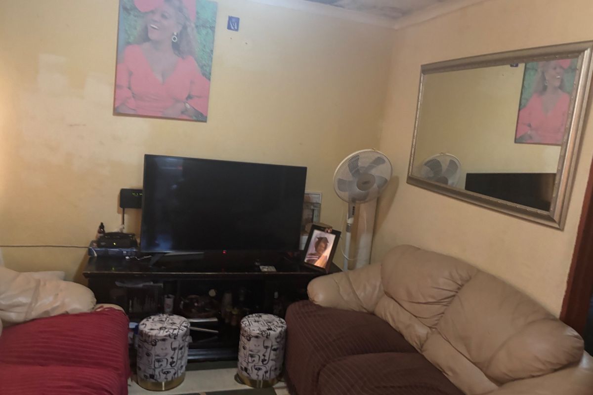 A living room space featuring visible ceiling water damage and wall paint wear, requiring maintenance and cosmetic updates to improve the interior condition.