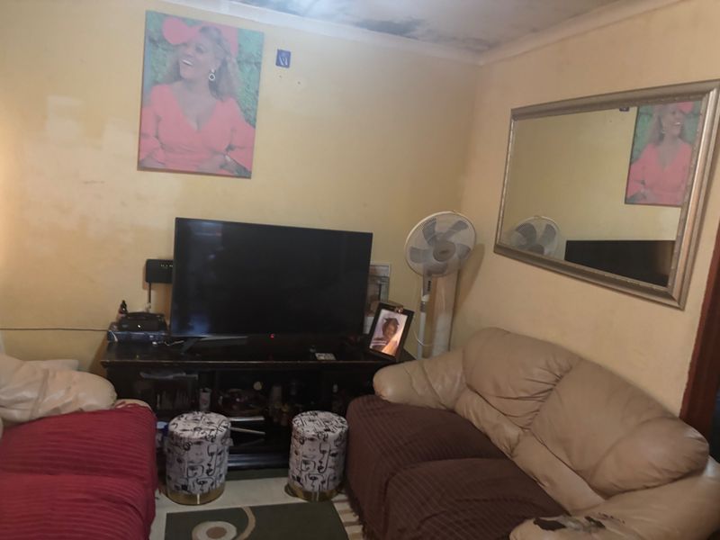 A living room space featuring visible ceiling water damage and wall paint wear, requiring maintenance and cosmetic updates to improve the interior condition.