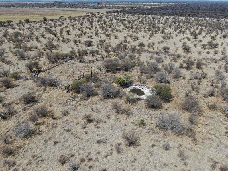 Aerial view of vacant residential land featuring a livestock enclosure and a weathered water reservoir amidst natural bushveld vegetation.