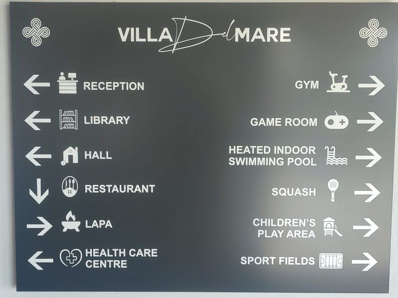 A directional signage board for Villa Del Mare, indicating the locations of various estate facilities and amenities.