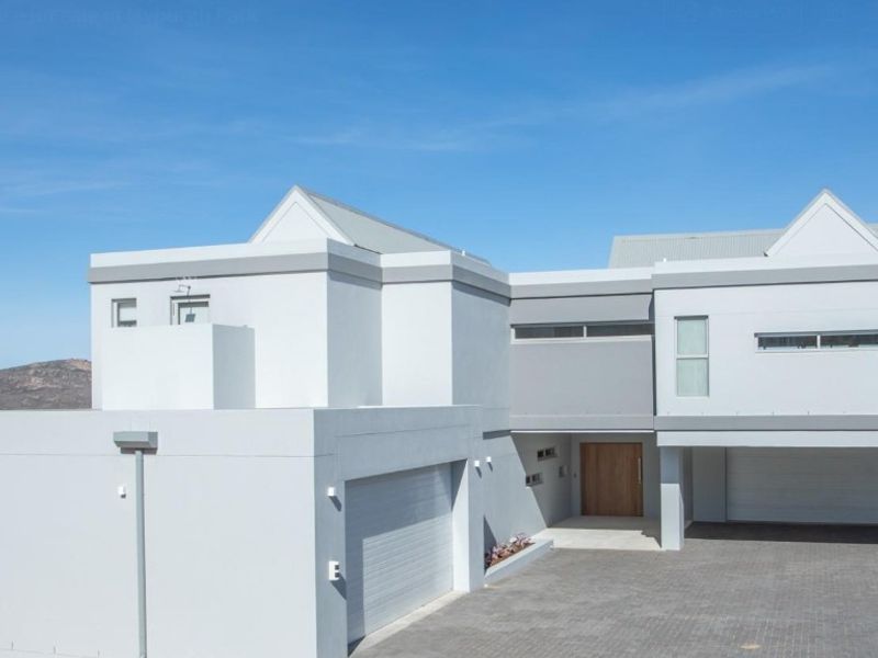 Modern double-story residence featuring a clean architectural facade, paved driveway, and integrated double garage.