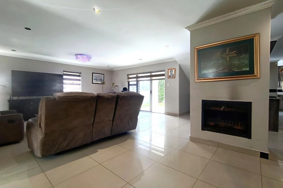 Spacious living room featuring large format floor tiles, a built-in fireplace, and sliding glass doors providing access to the outdoor area.
