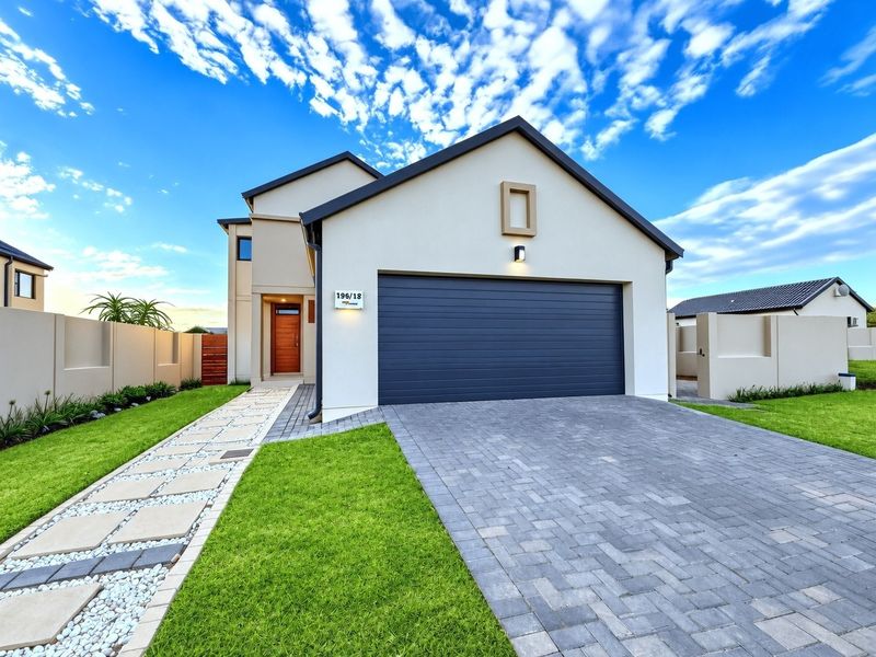 Modern front elevation featuring a double garage, paved driveway, and a landscaped walkway leading to the main entrance.