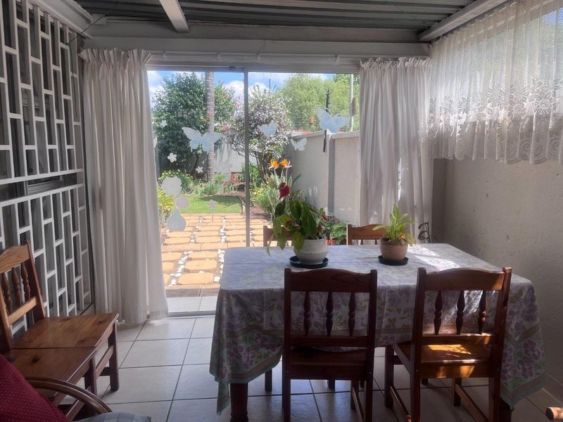 A covered patio area featuring tiled flooring and a sliding glass door providing direct access to the rear garden.