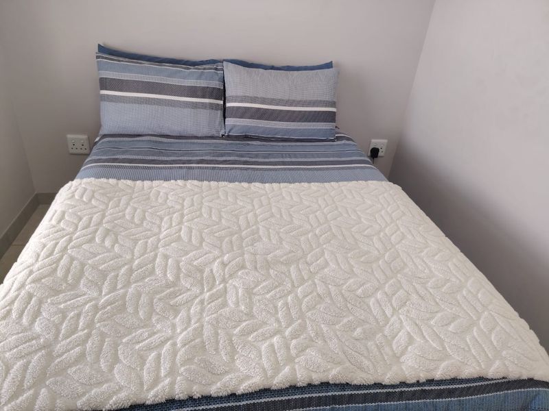 A simple bedroom space featuring neutral wall finishes and accessible electrical power points.