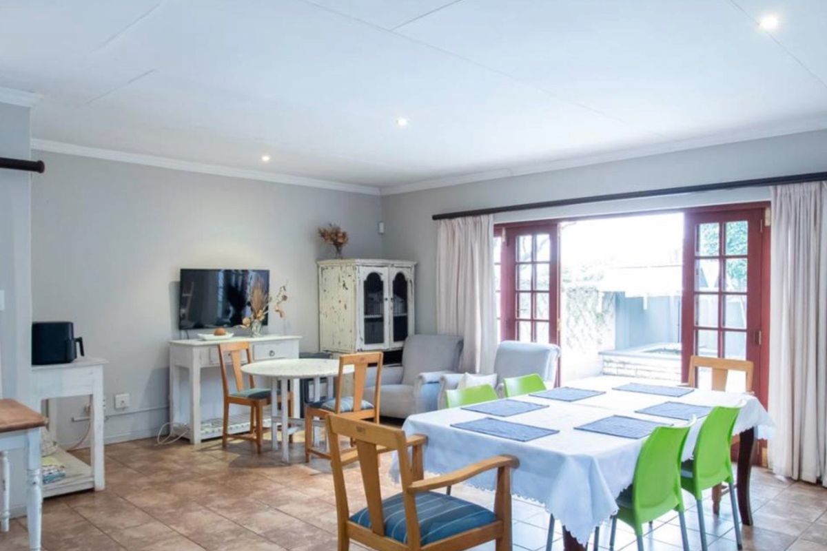 Spacious living and dining area featuring tiled flooring, recessed lighting, and double french doors providing direct access to the outdoor patio area.