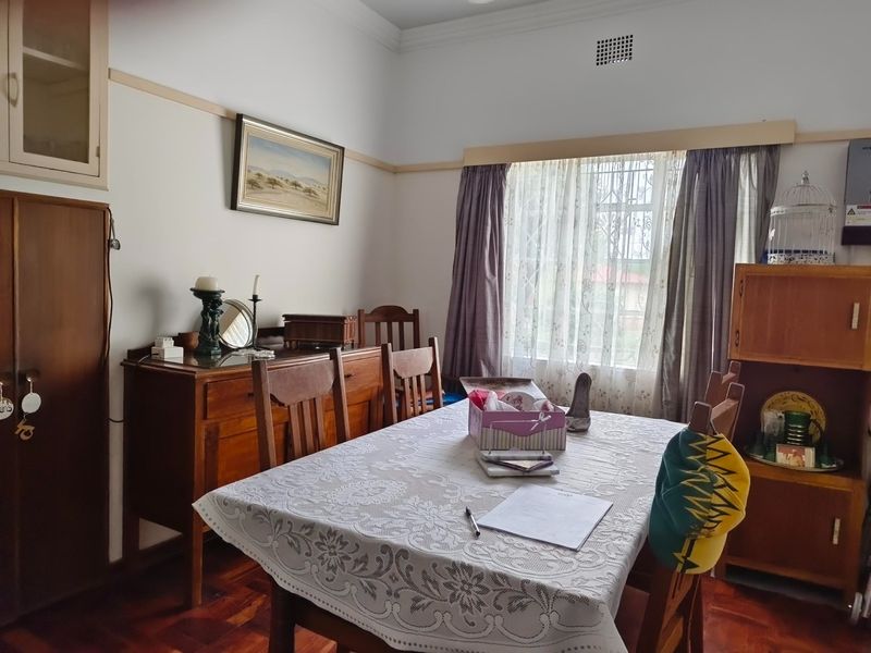 A dining room featuring classic parquet flooring, built-in cabinetry, and traditional architectural details like picture rails and cornicing.