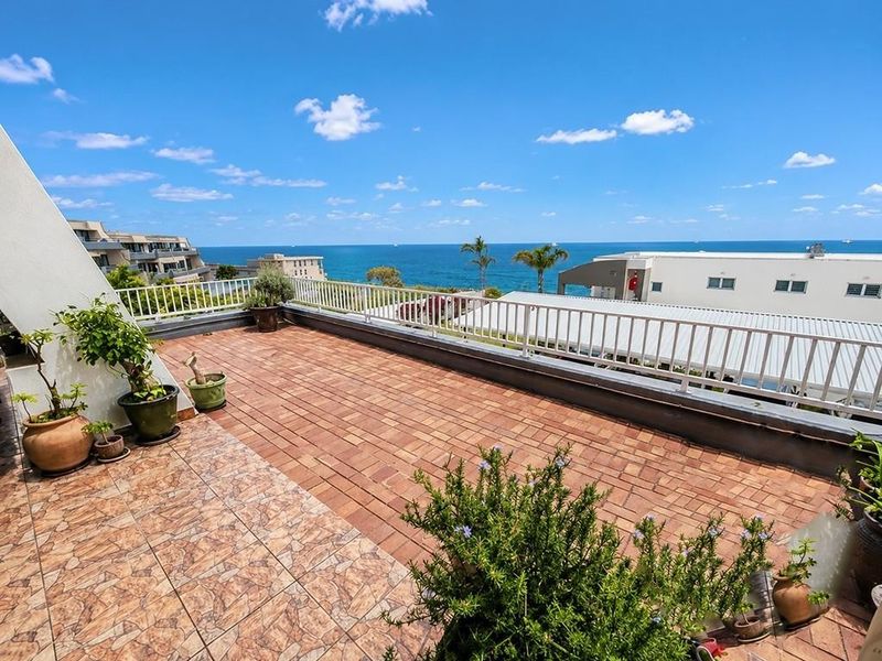 Spacious open-air balcony featuring tiled flooring, a protective metal balustrade, and expansive panoramic ocean views.