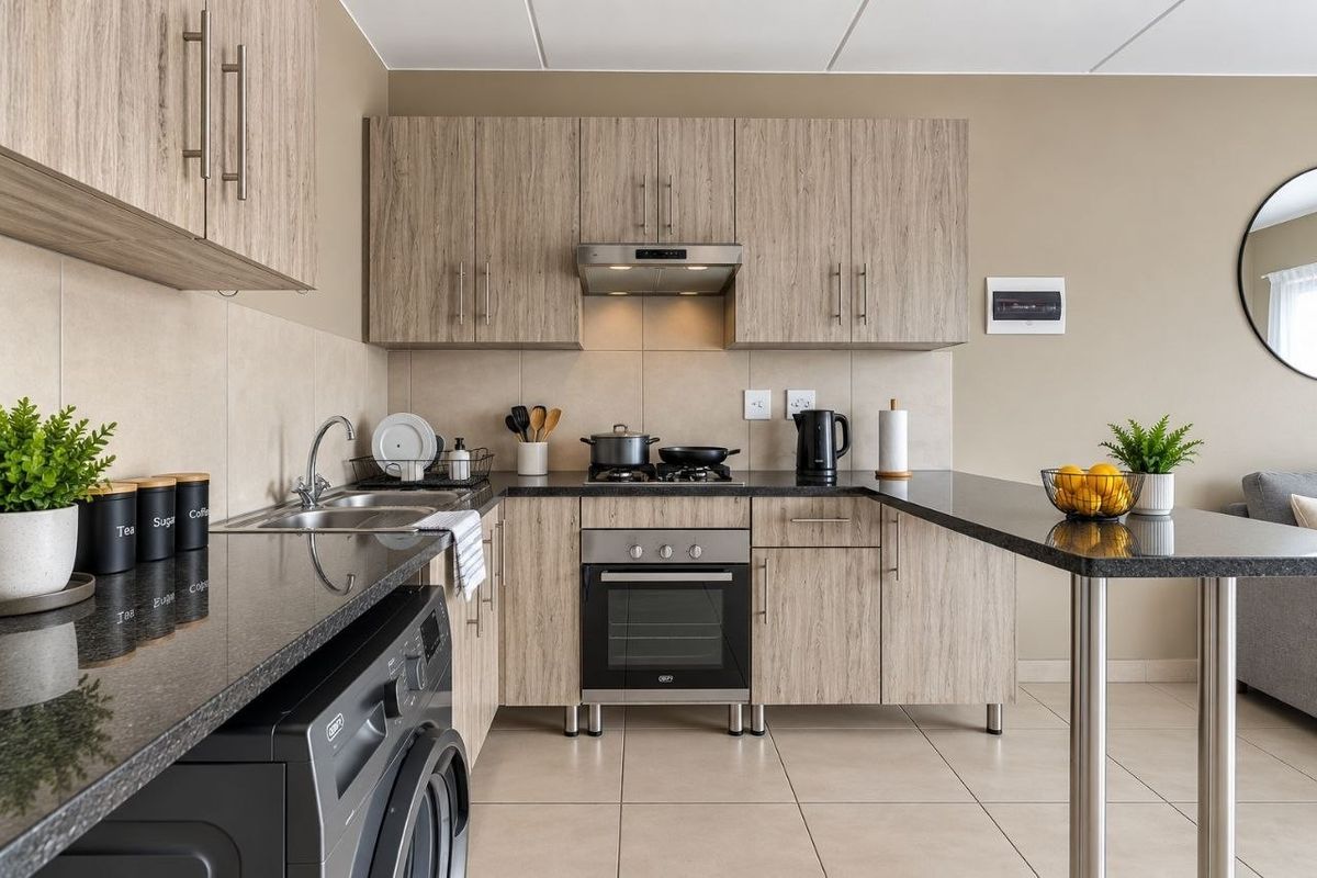Modern kitchen featuring wood-grain cabinetry, granite countertops, integrated stainless steel oven and hob, and a convenient breakfast bar extension.