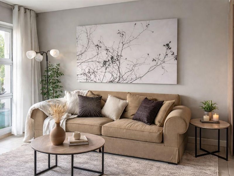 A well-maintained living room featuring neutral wall tones, tiled flooring, and a large sliding glass door providing natural light.