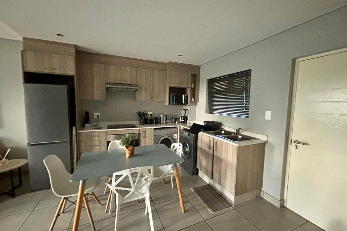 Compact kitchen featuring light wood-finish cabinetry, laminate countertops, integrated appliances, and tiled flooring, offering a functional and modern layout.