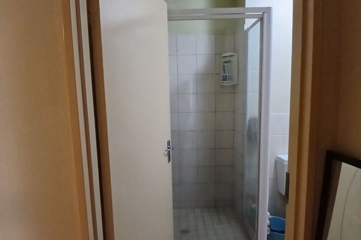 A small bathroom featuring a shower enclosure and toilet, requiring ceiling repairs and general refurbishment to improve the overall condition.