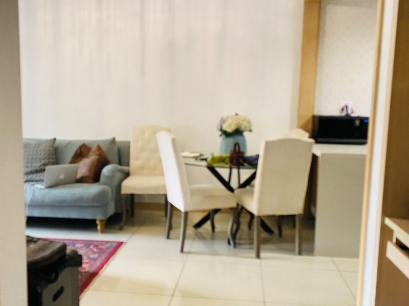 An open-plan living and dining area featuring tiled flooring and neutral wall finishes, providing a functional space for daily living.