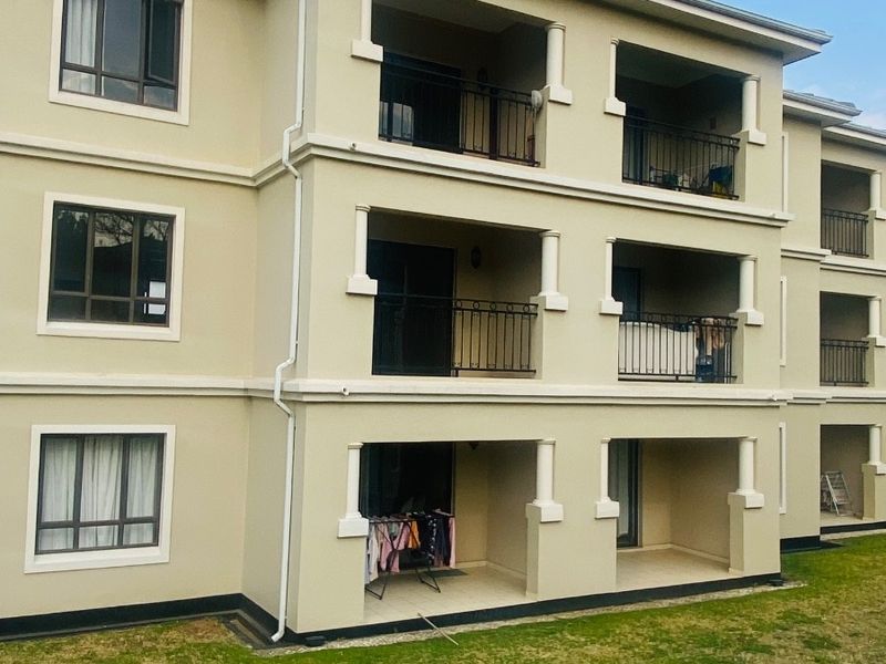A multi-story apartment building exterior featuring stacked balconies with metal railings and neutral-toned facade finishes.