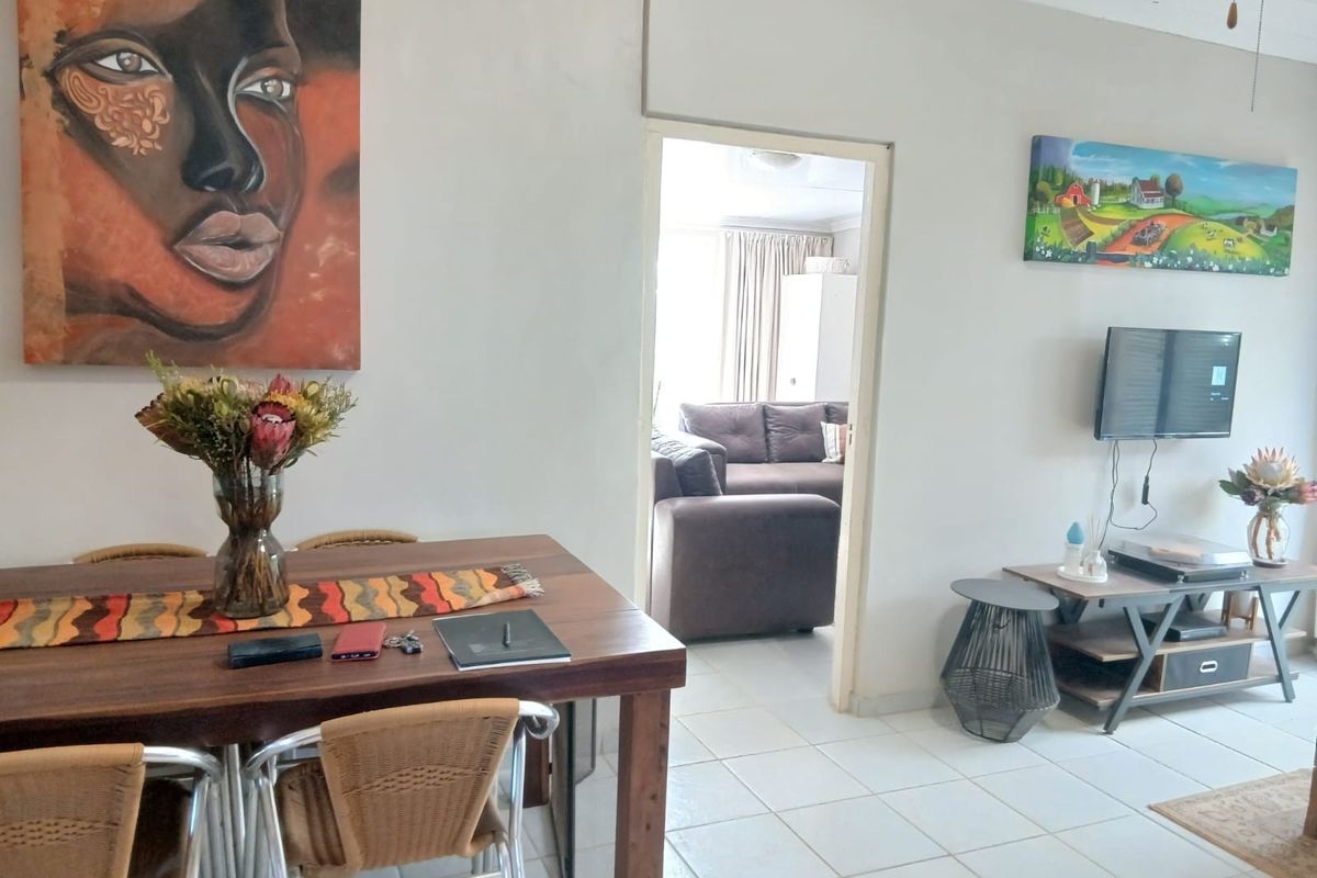 A living area featuring tiled flooring and a doorway leading to an adjacent room, providing a functional and connected living space.