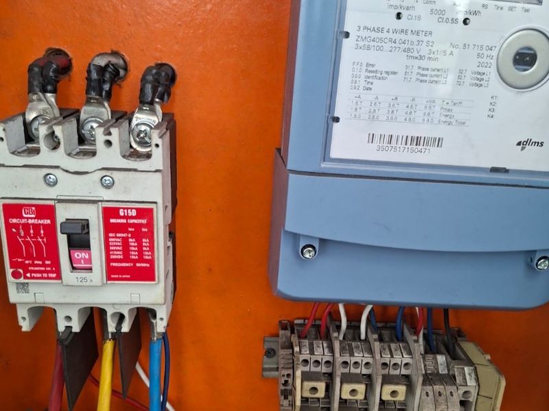 A close-up view of an industrial electrical distribution board featuring a three-phase electricity meter and a 125A circuit breaker.
