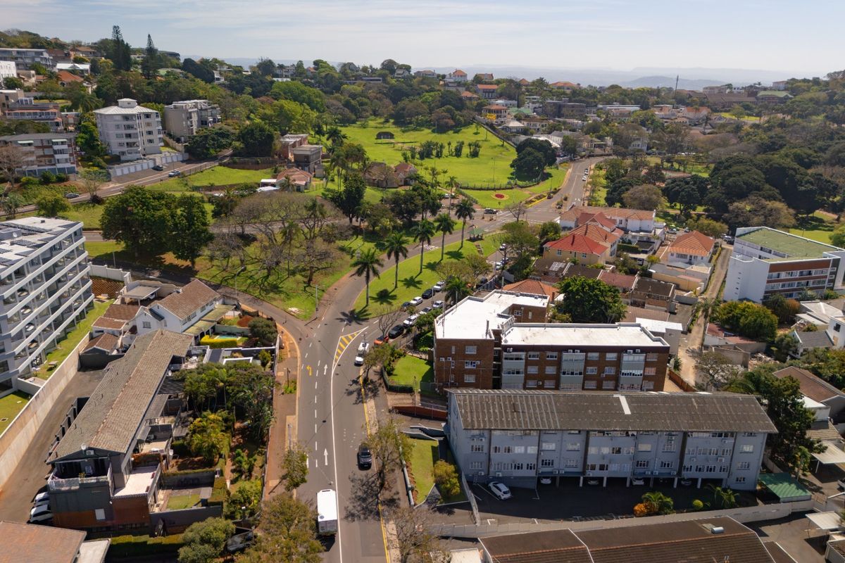 An aerial view of the surrounding residential neighborhood, showcasing apartment complexes, local road infrastructure, and green parkland areas.