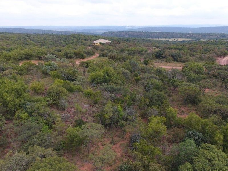 An aerial view of a large, undeveloped residential land parcel featuring native bushveld vegetation and an existing dirt access track.