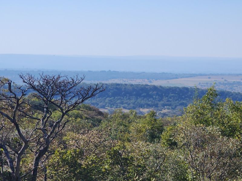 A scenic, elevated landscape view overlooking natural bushveld and rolling hills, showcasing the expansive natural surroundings of the property.