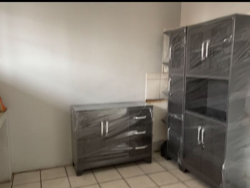 A utility space featuring tiled flooring and dark cabinetry, currently in a functional state.