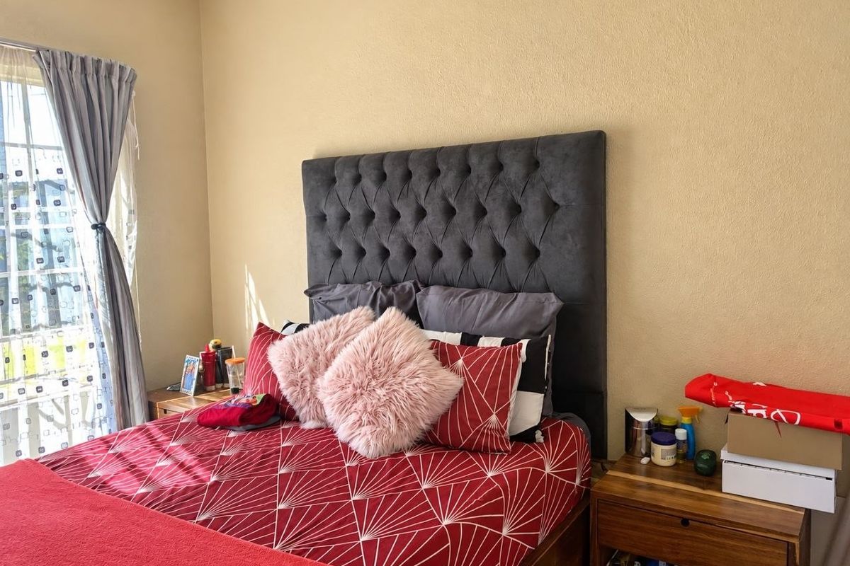 A bedroom featuring a window with curtains and a neutral wall finish, providing a functional space for rest.