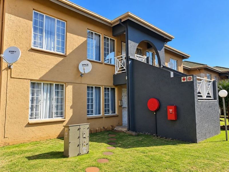 Exterior view of a multi-story apartment building featuring a balcony, security gates, and installed fire safety equipment.