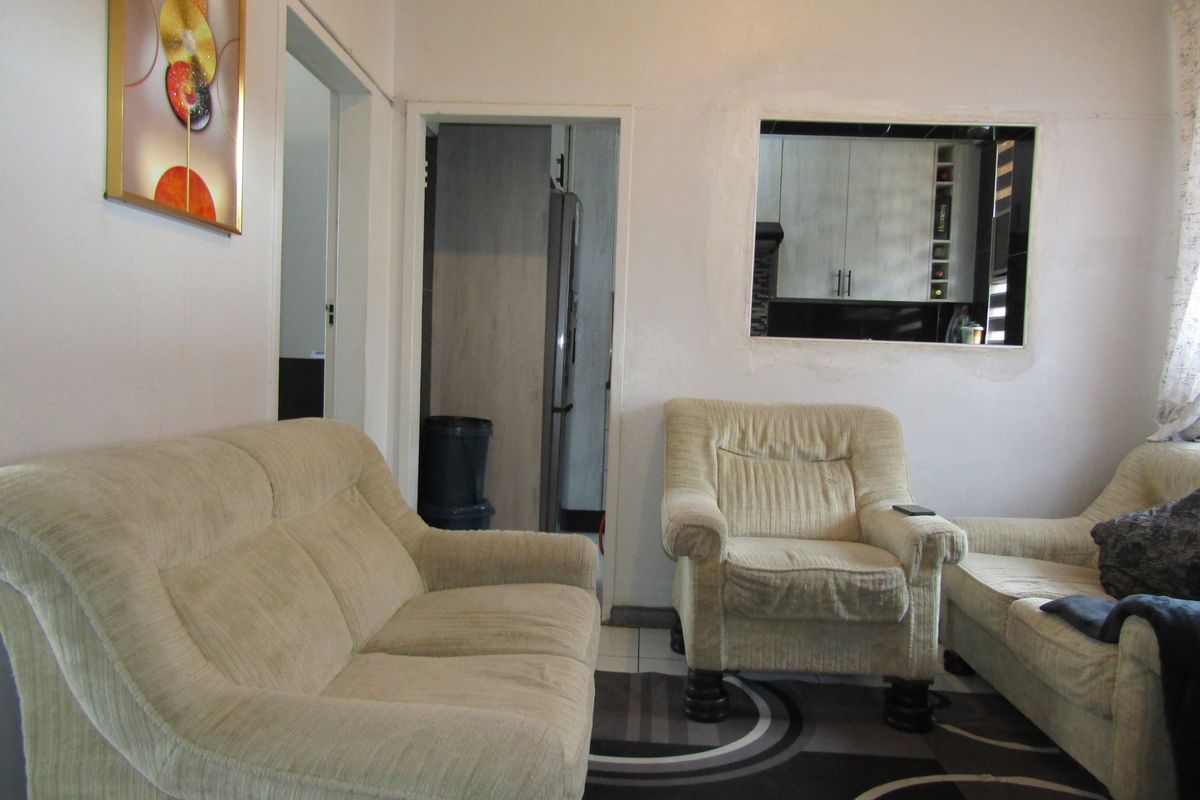 Living room featuring a serving hatch connecting to the kitchen area and tiled flooring throughout.