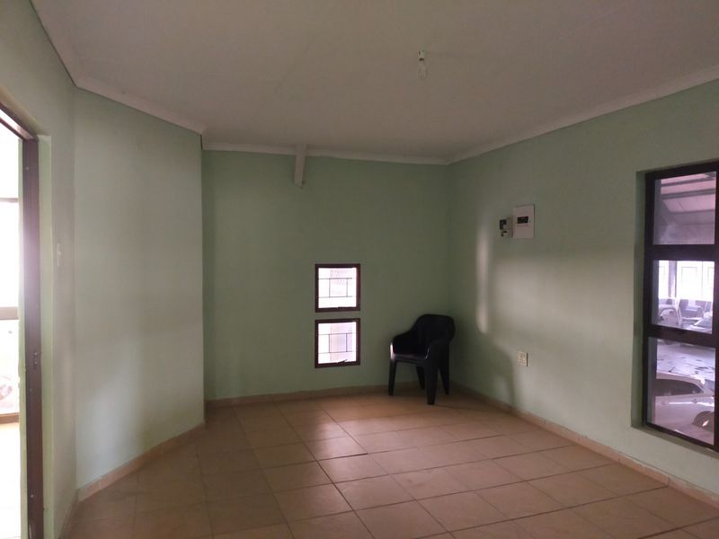 A vacant office space featuring neutral tiled flooring, clean walls, and natural light from multiple windows.