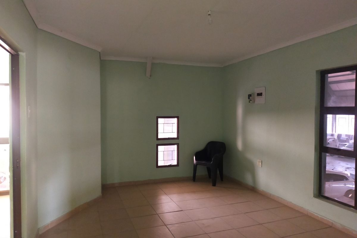 A vacant office space featuring neutral tiled flooring, clean walls, and natural light from multiple windows.
